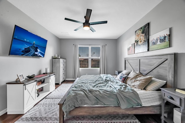 bedroom featuring a ceiling fan, baseboards, visible vents, and wood finished floors