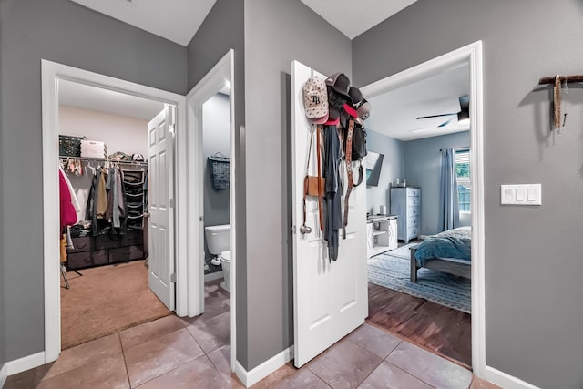 hallway with tile patterned flooring and baseboards