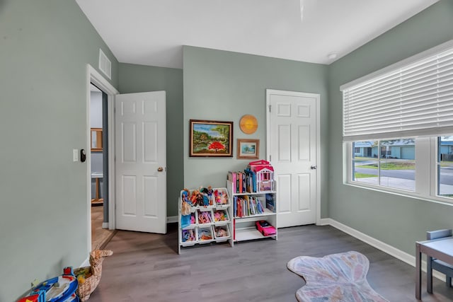 playroom with visible vents, baseboards, and wood finished floors