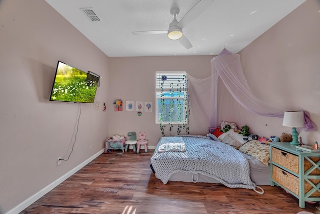 bedroom featuring baseboards, visible vents, ceiling fan, and wood finished floors