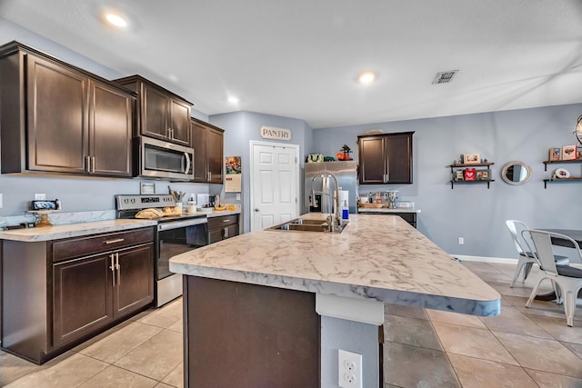 kitchen with dark brown cabinetry, appliances with stainless steel finishes, light countertops, and light tile patterned flooring