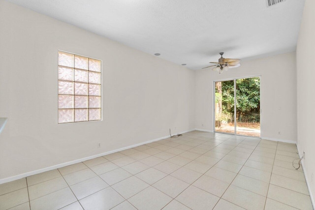 unfurnished room with light tile patterned floors, a ceiling fan, and baseboards