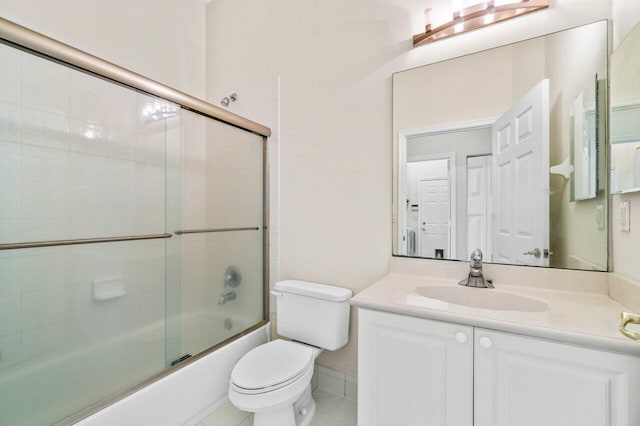 full bath featuring toilet, tile patterned flooring, combined bath / shower with glass door, and vanity