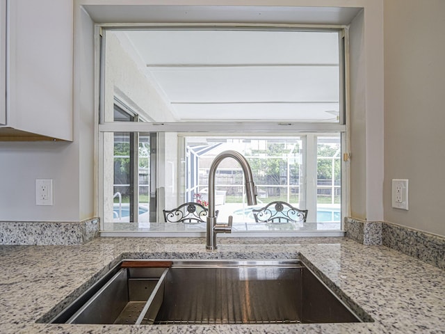 kitchen featuring light stone counters and a sink
