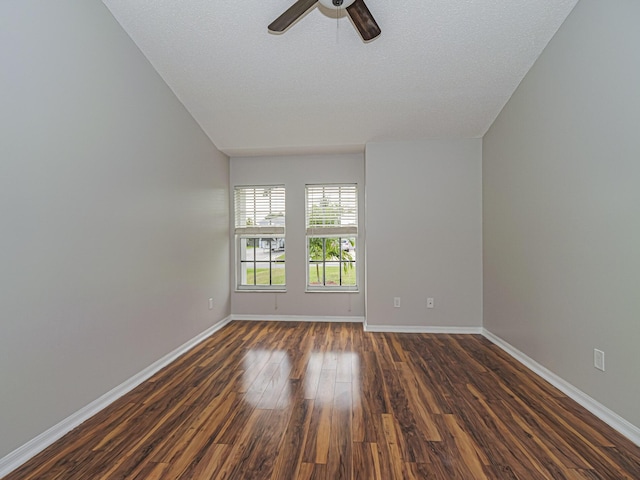 empty room with ceiling fan, dark wood-type flooring, and baseboards