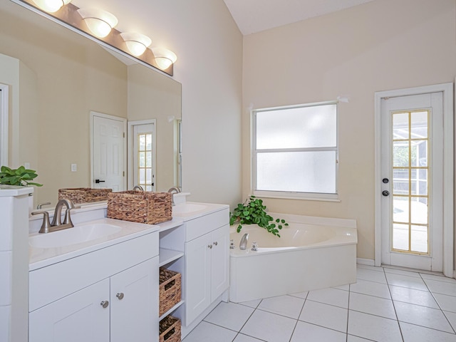 full bathroom featuring two vanities, tile patterned flooring, a garden tub, and a sink