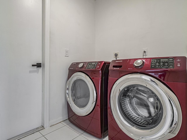 clothes washing area featuring laundry area, tile patterned flooring, and washer and dryer