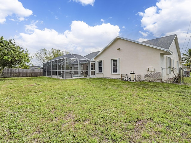 rear view of property featuring a lawn, a fenced backyard, a lanai, central air condition unit, and stucco siding