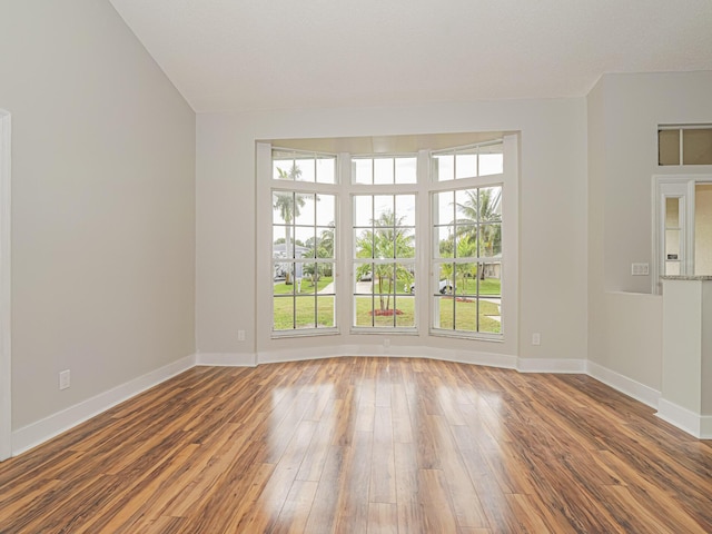 unfurnished room featuring baseboards and wood finished floors