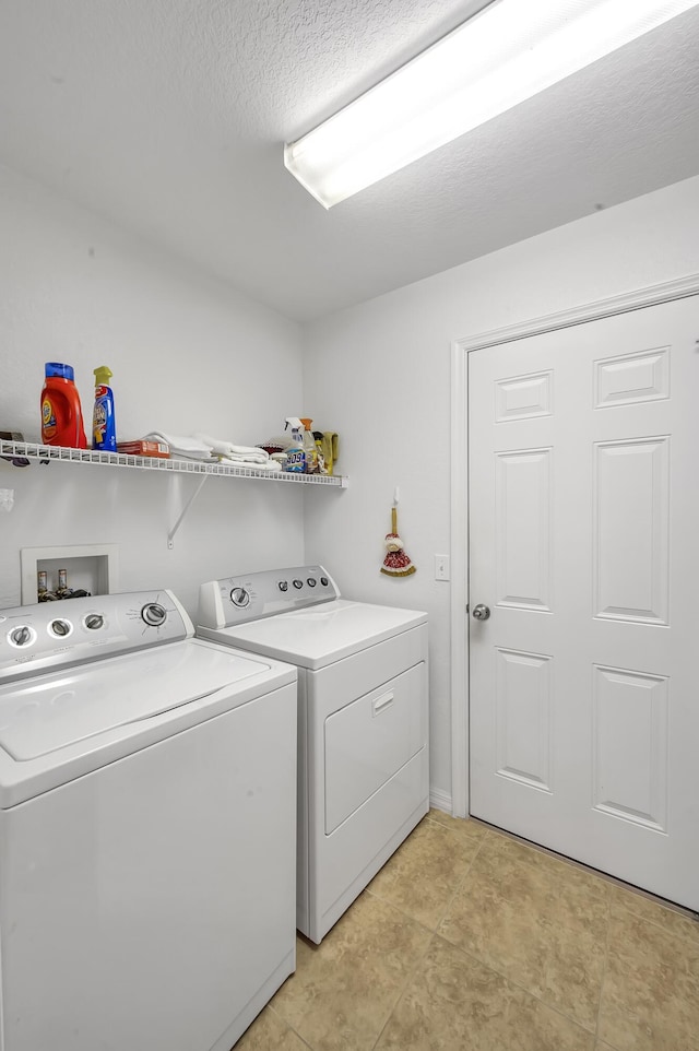 laundry room with a textured ceiling, laundry area, and separate washer and dryer