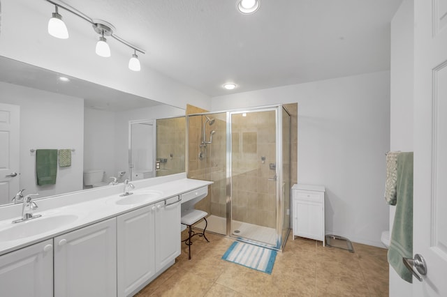 bathroom featuring a sink, a shower stall, and toilet