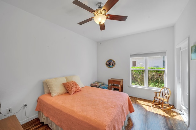 bedroom featuring ceiling fan, baseboards, and wood finished floors