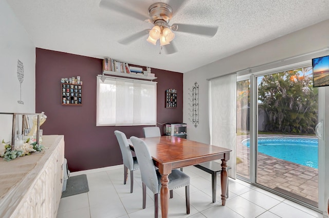 dining space featuring a textured ceiling, a ceiling fan, and baseboards