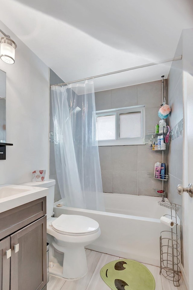 full bath with toilet, shower / bath combo with shower curtain, and vanity