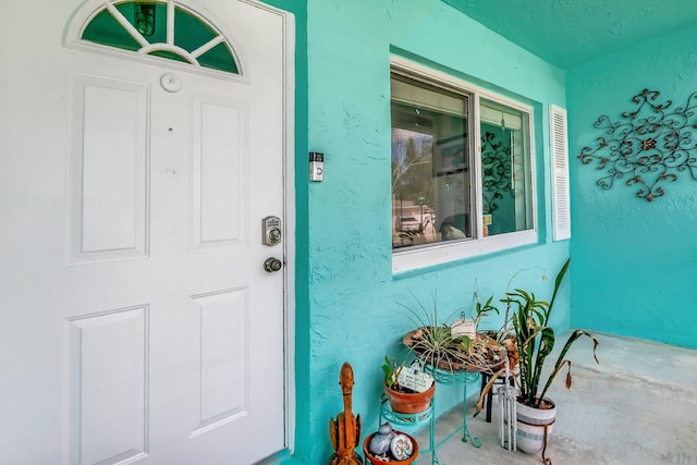 doorway to property featuring stucco siding