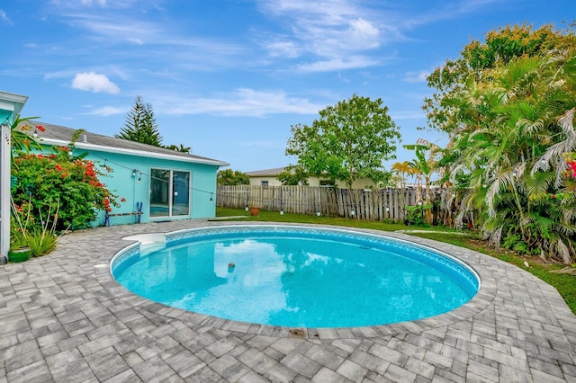 view of swimming pool with a fenced in pool, fence, and a patio