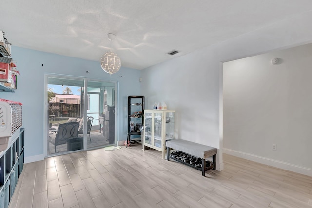 interior space with wood finished floors, visible vents, and baseboards