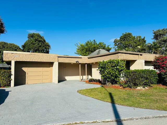 view of front of house featuring a front lawn, decorative driveway, and an attached garage