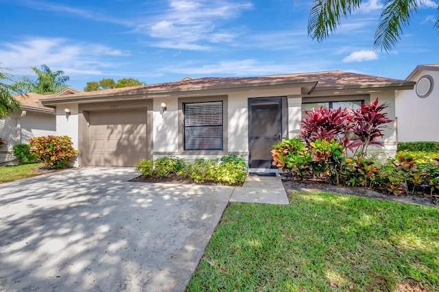 view of front facade with a garage, driveway, a front lawn, and stucco siding