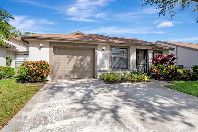 single story home featuring a garage, driveway, and stucco siding