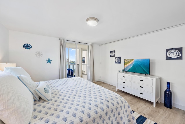 bedroom with baseboards, light wood-style floors, and access to exterior