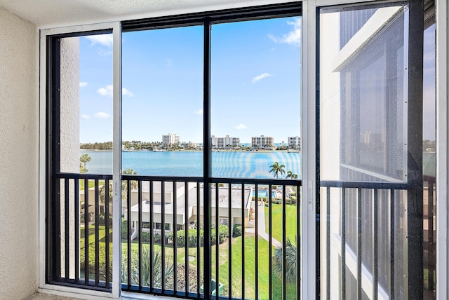 sunroom featuring a water view and a view of city
