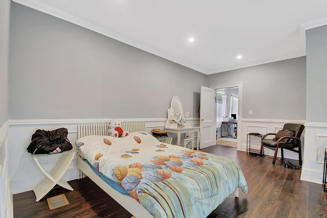 bedroom featuring a wainscoted wall, ornamental molding, dark wood-type flooring, a decorative wall, and recessed lighting