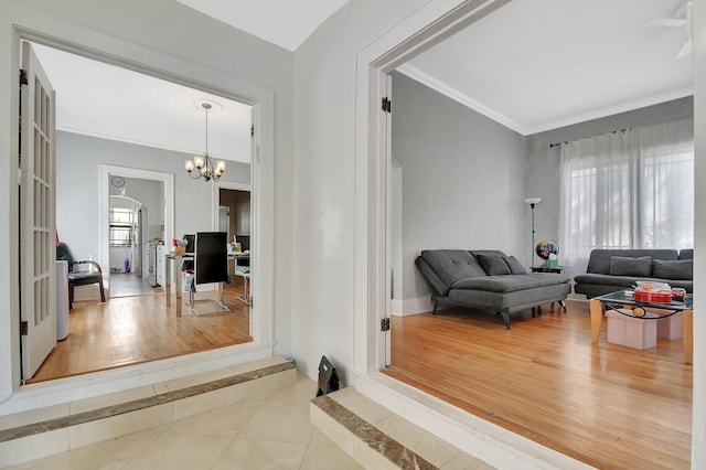 hallway with a chandelier, wood finished floors, and crown molding