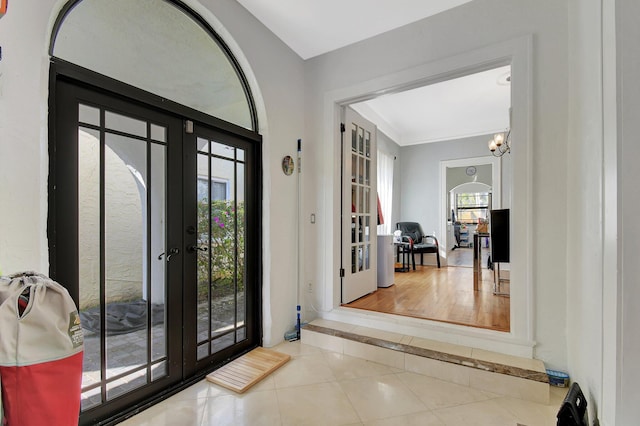 entrance foyer with french doors, tile patterned flooring, and a notable chandelier