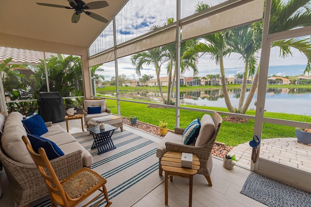 sunroom with ceiling fan, vaulted ceiling, and a water view