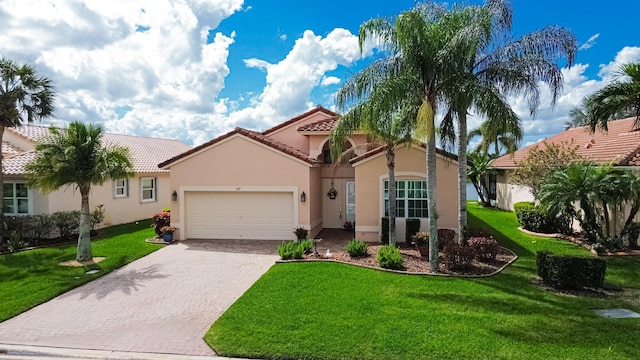 mediterranean / spanish-style house featuring an attached garage, a tiled roof, decorative driveway, stucco siding, and a front yard