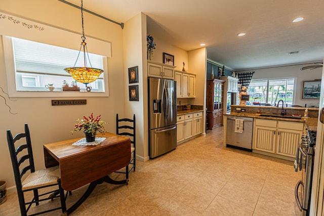 kitchen with recessed lighting, a sink, hanging light fixtures, appliances with stainless steel finishes, and cream cabinetry