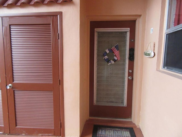 doorway to property featuring stucco siding