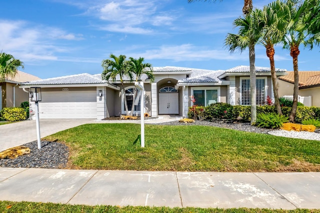 single story home with a garage, concrete driveway, a tiled roof, stucco siding, and a front yard