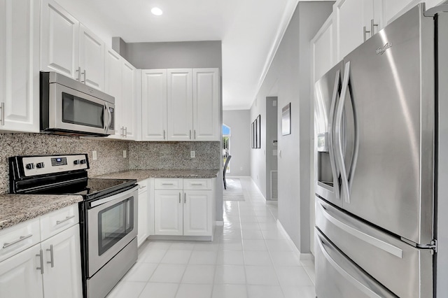 kitchen with tasteful backsplash, visible vents, appliances with stainless steel finishes, light tile patterned flooring, and white cabinetry