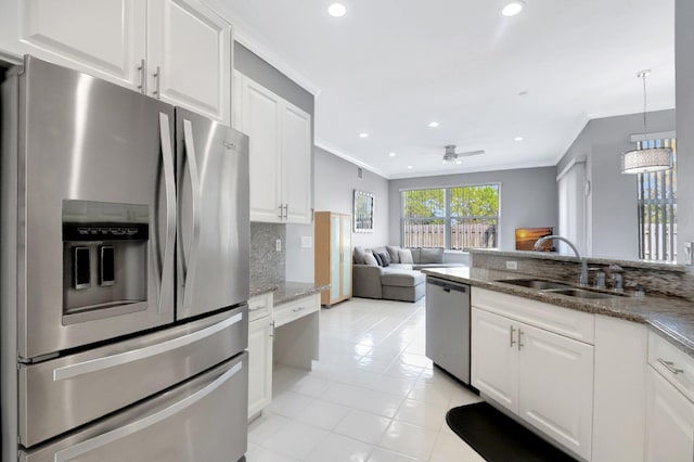 kitchen with crown molding, decorative backsplash, stainless steel appliances, and a sink