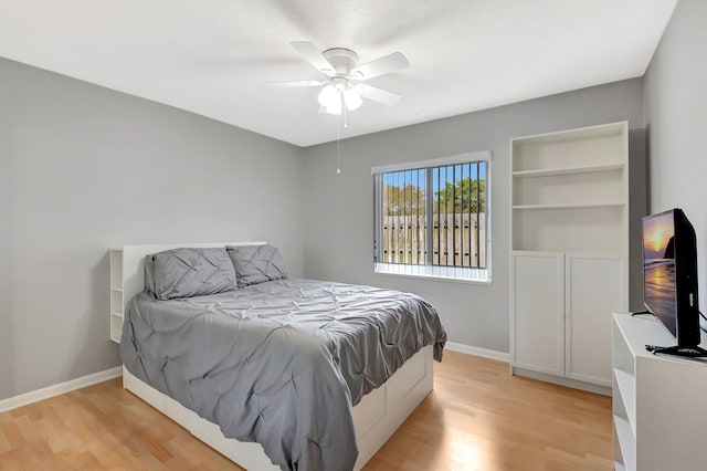 bedroom featuring a ceiling fan, light wood-style flooring, and baseboards