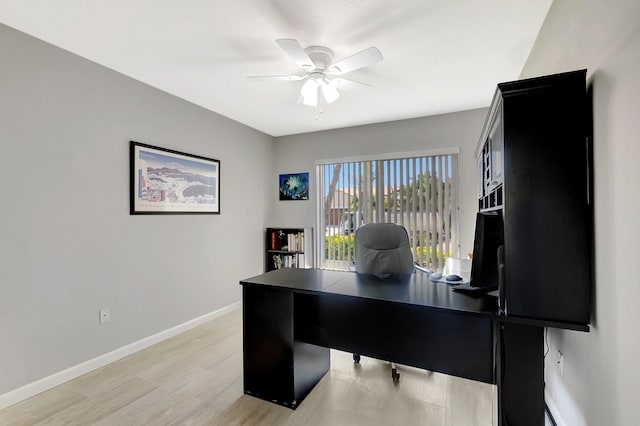 home office with light wood finished floors, baseboards, and a ceiling fan