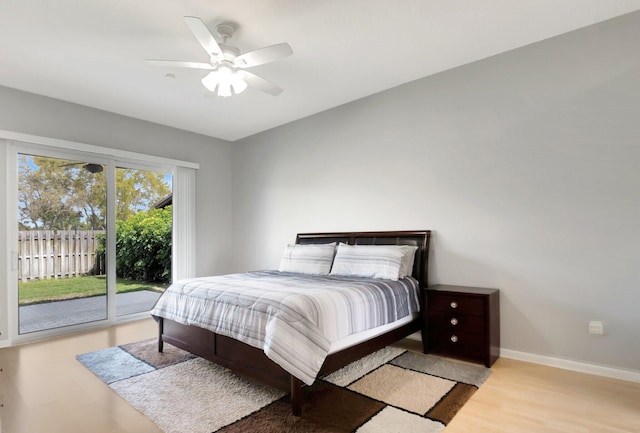 bedroom featuring access to exterior, a ceiling fan, baseboards, and wood finished floors