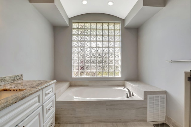 bathroom featuring vanity, a garden tub, and visible vents