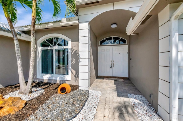 view of exterior entry featuring stucco siding