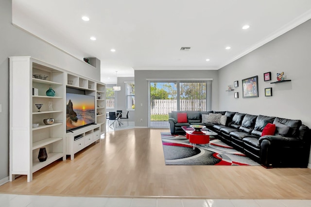 living room with light wood-style flooring, visible vents, crown molding, and recessed lighting