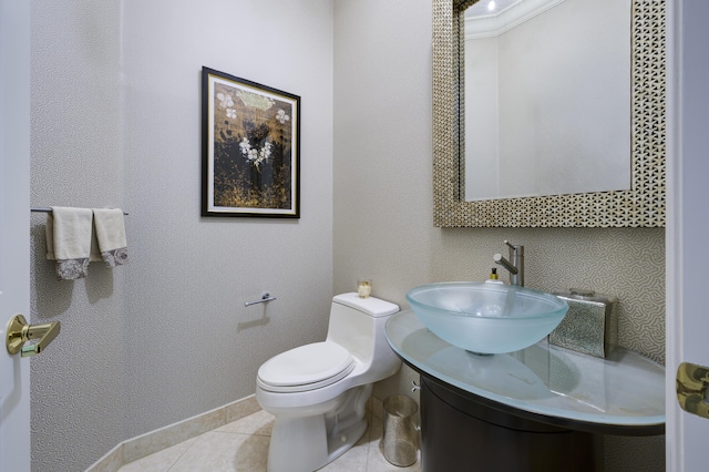 half bath with toilet, vanity, and tile patterned floors