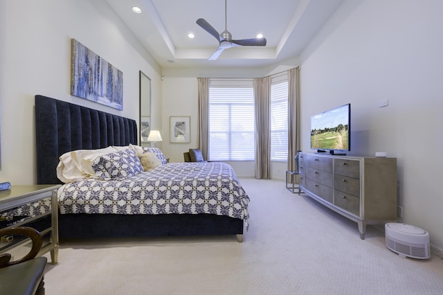 bedroom with light carpet, ceiling fan, a raised ceiling, and recessed lighting