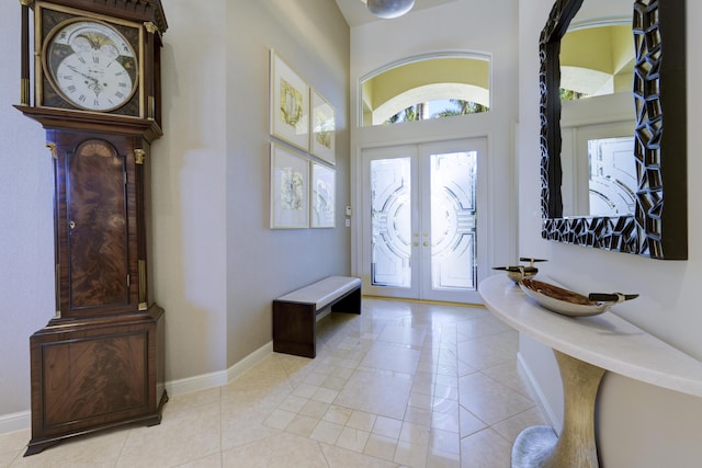 entryway featuring french doors, light tile patterned flooring, and baseboards