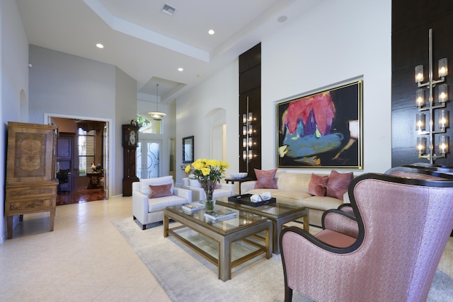 living area with a high ceiling, visible vents, arched walkways, and recessed lighting