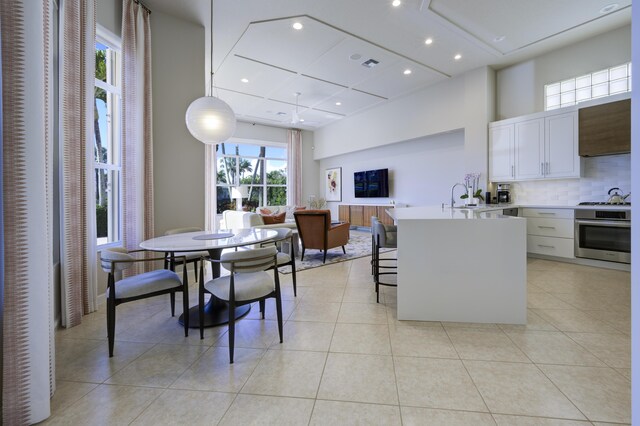 dining room with recessed lighting, a high ceiling, visible vents, and light tile patterned flooring