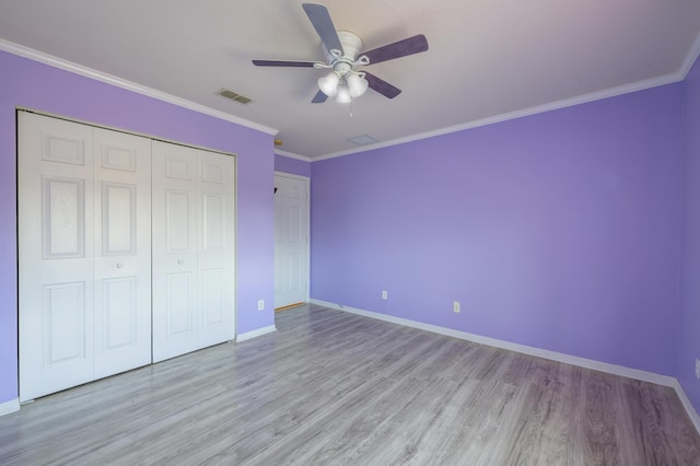 unfurnished bedroom with ornamental molding, visible vents, light wood-style floors, and baseboards