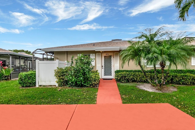 view of front facade featuring a front yard, fence, and stucco siding