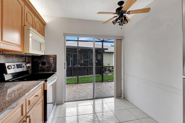 kitchen with decorative backsplash, white microwave, a ceiling fan, a textured ceiling, and stainless steel range with electric stovetop